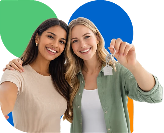 Two women smiling while holding house keys for NDIS disability housing